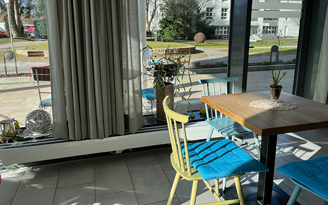 Cafétisch mit Stühlen und blauen Sitzkissen - CiK - Café im Klinikum